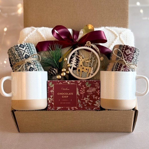 Cozy gift box with knit blanket, mugs and cocoa treats
