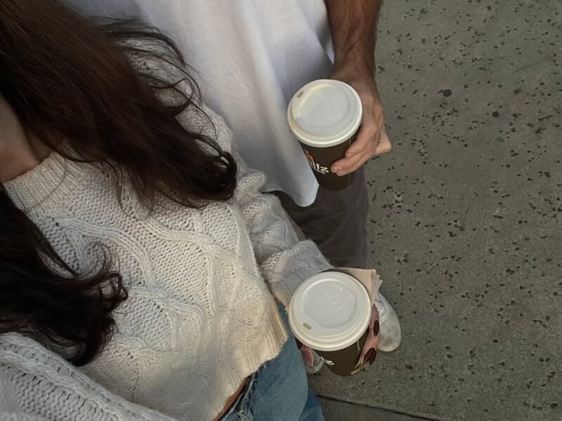 Overhead shot of a couple holding takeaway coffee cups on a walk together