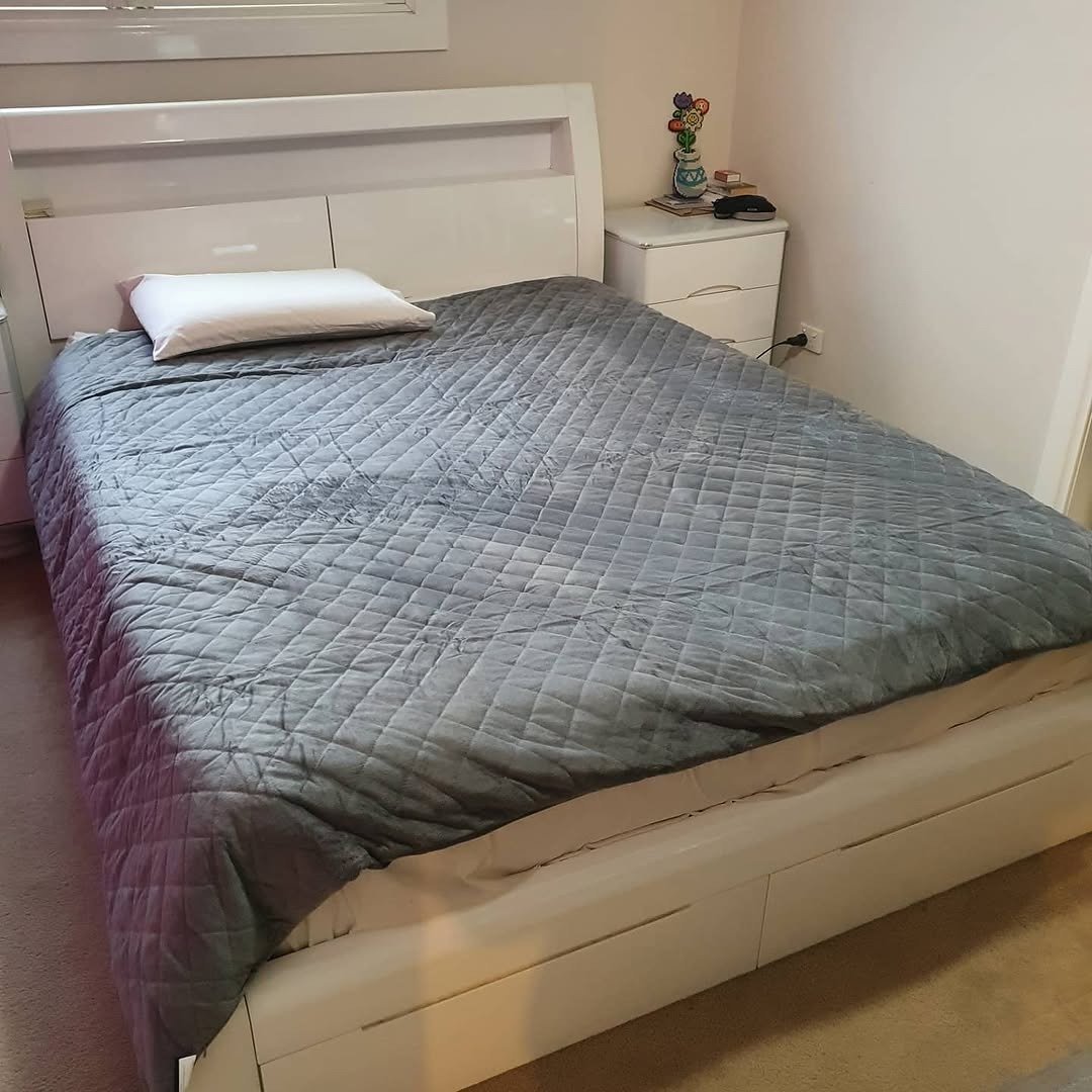 Grey weighted blanket draped on bed