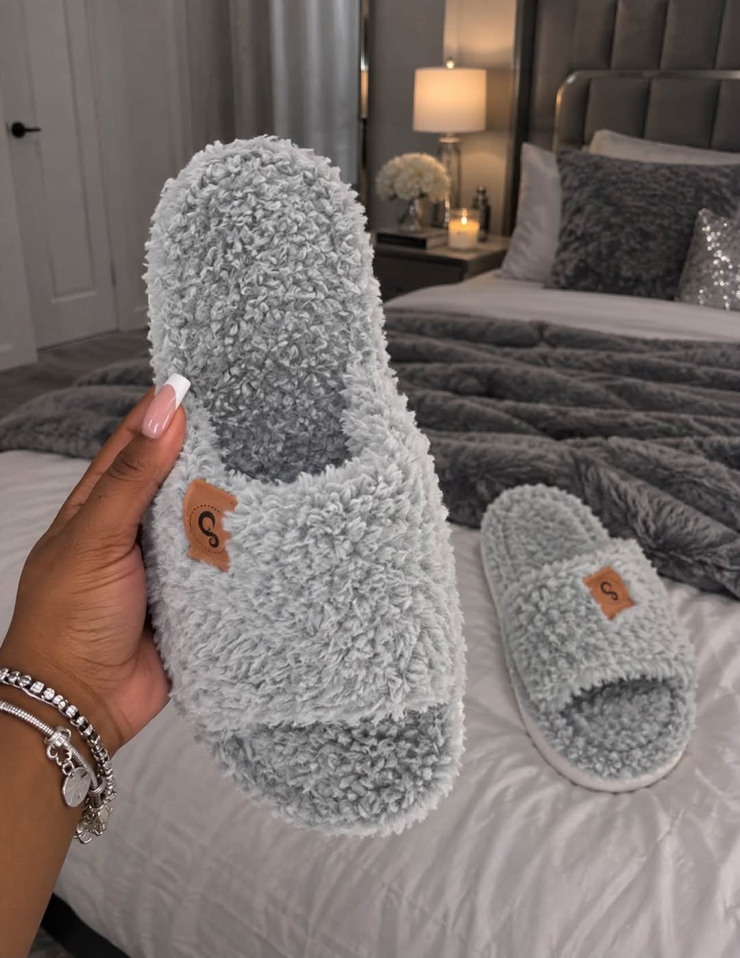 Grey fuzzy memory foam slippers by bed