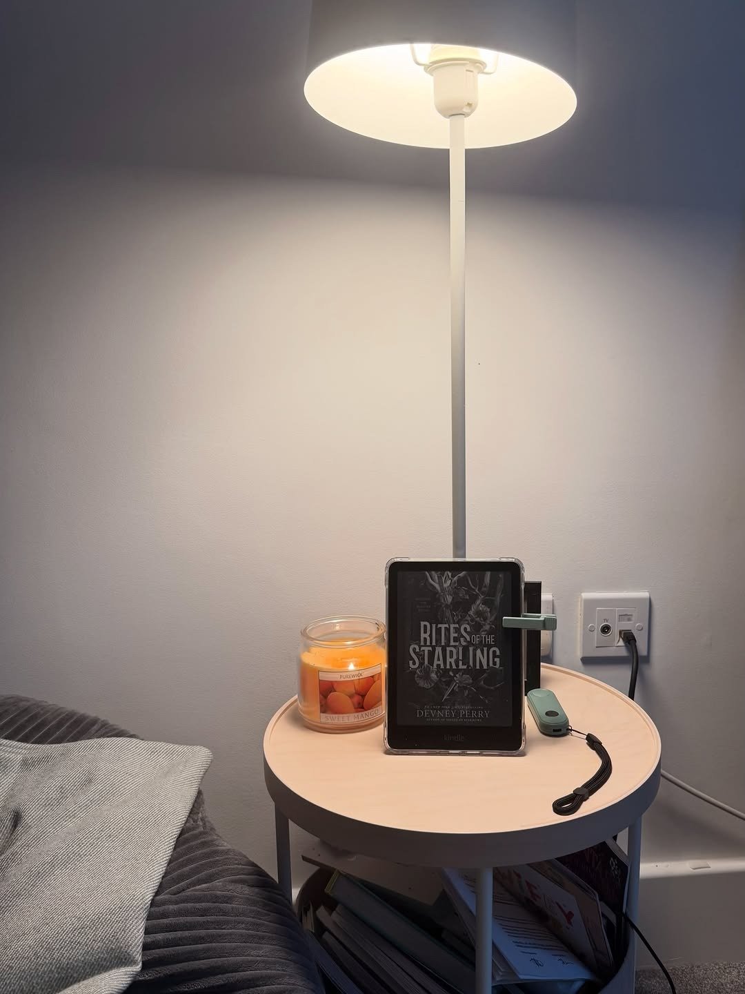Cozy bedside with lamp, book and throw