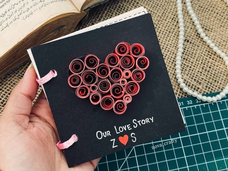 Handmade love book with quilled heart cover on craft mat