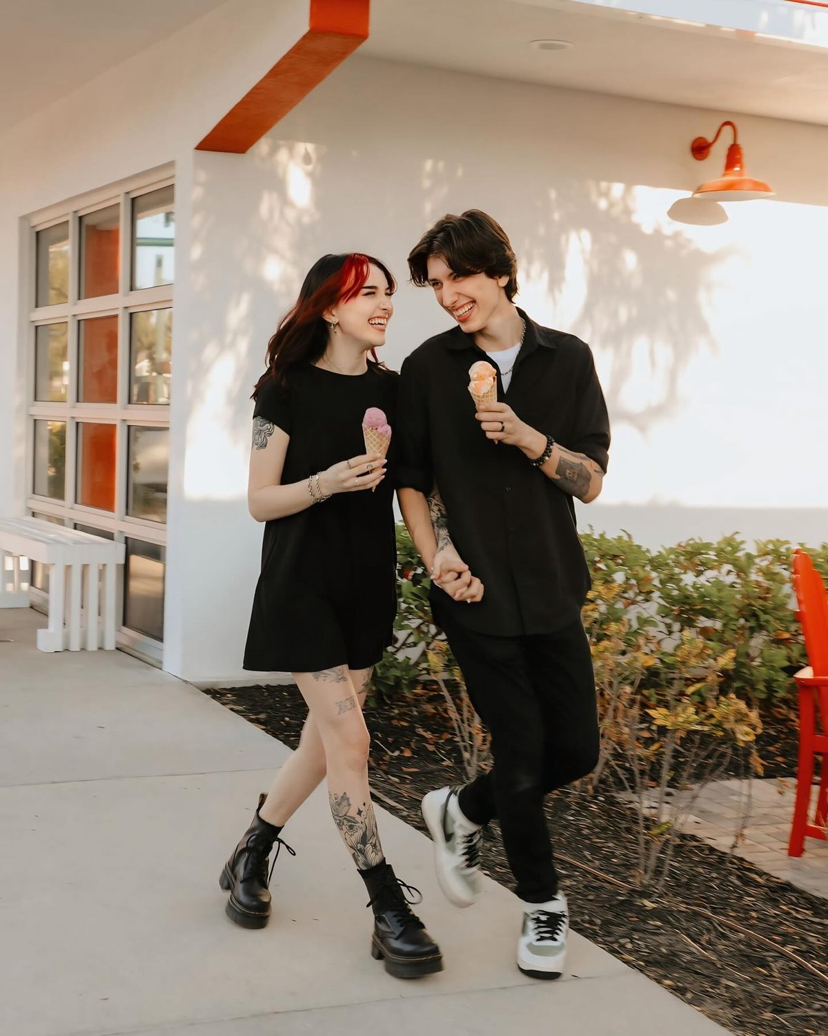 Couple walking hand in hand with ice cream cones, laughing