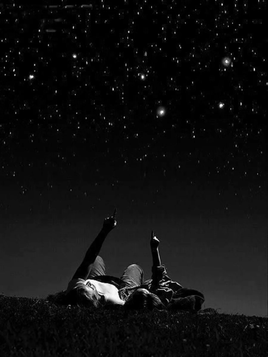 Couple stargazing together under a starry night sky