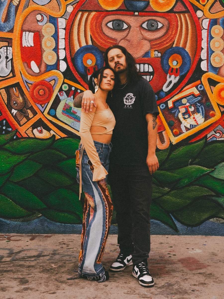 Couple posing in front of a colorful downtown mural