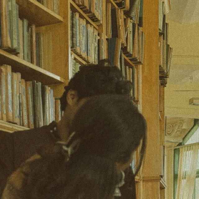 Couple embracing in a library aisle between tall shelves