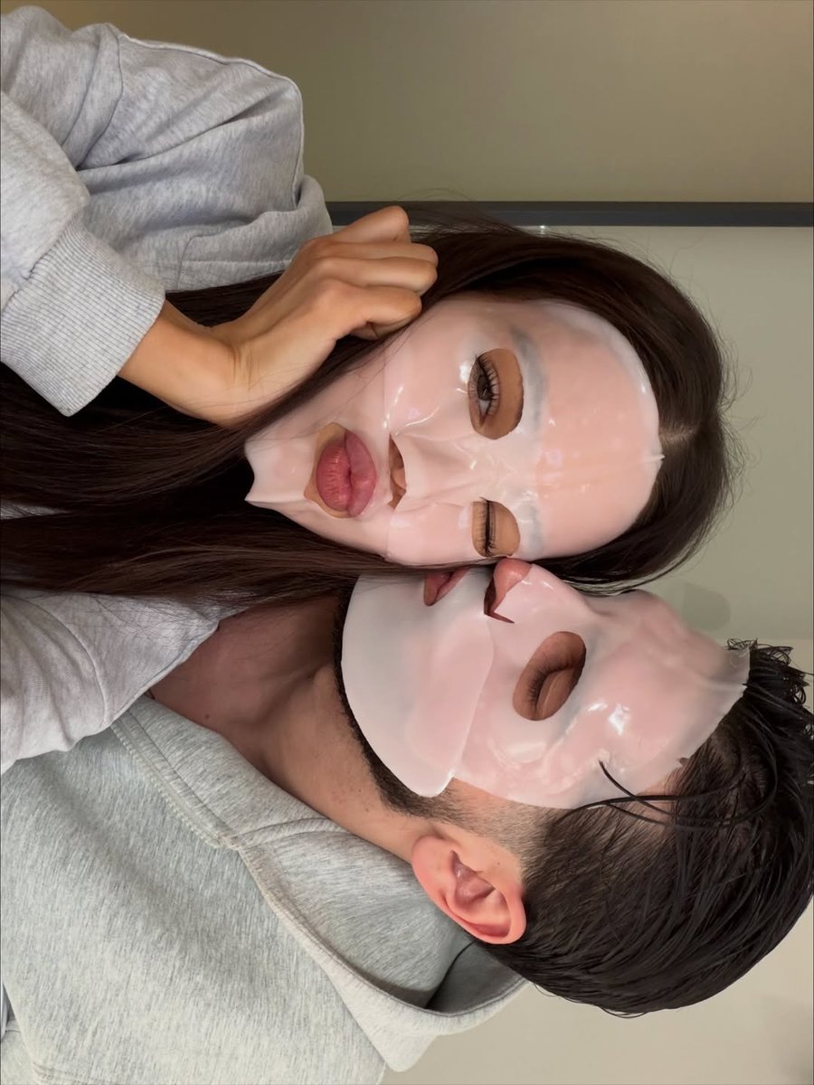 Couple wearing sheet face masks together at home