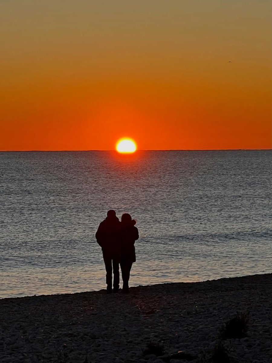 Couple watching a sunrise over the ocean together