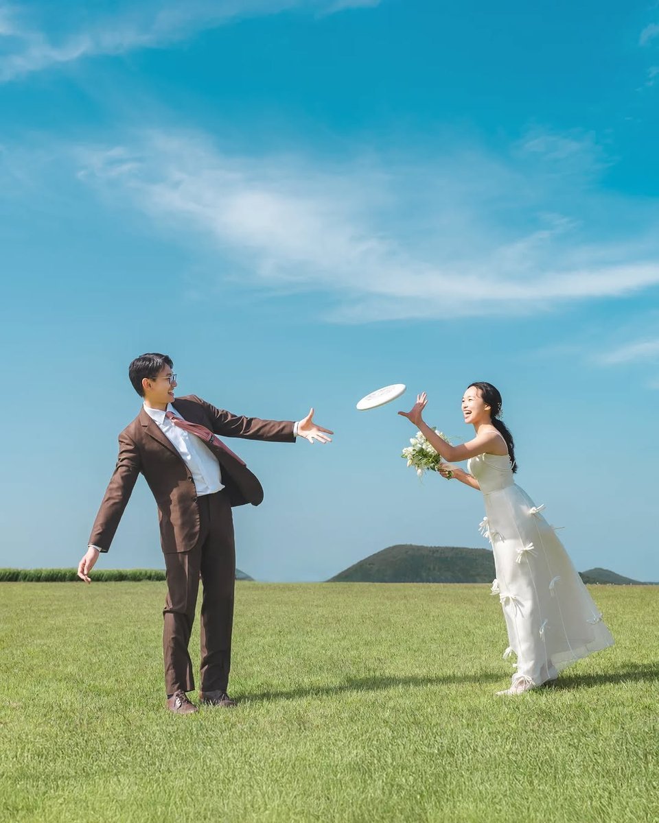 Couple tossing a frisbee back and forth in a grassy field