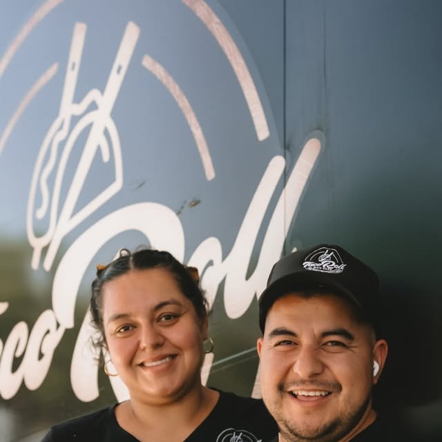 Couple standing in front of a colorful food truck
