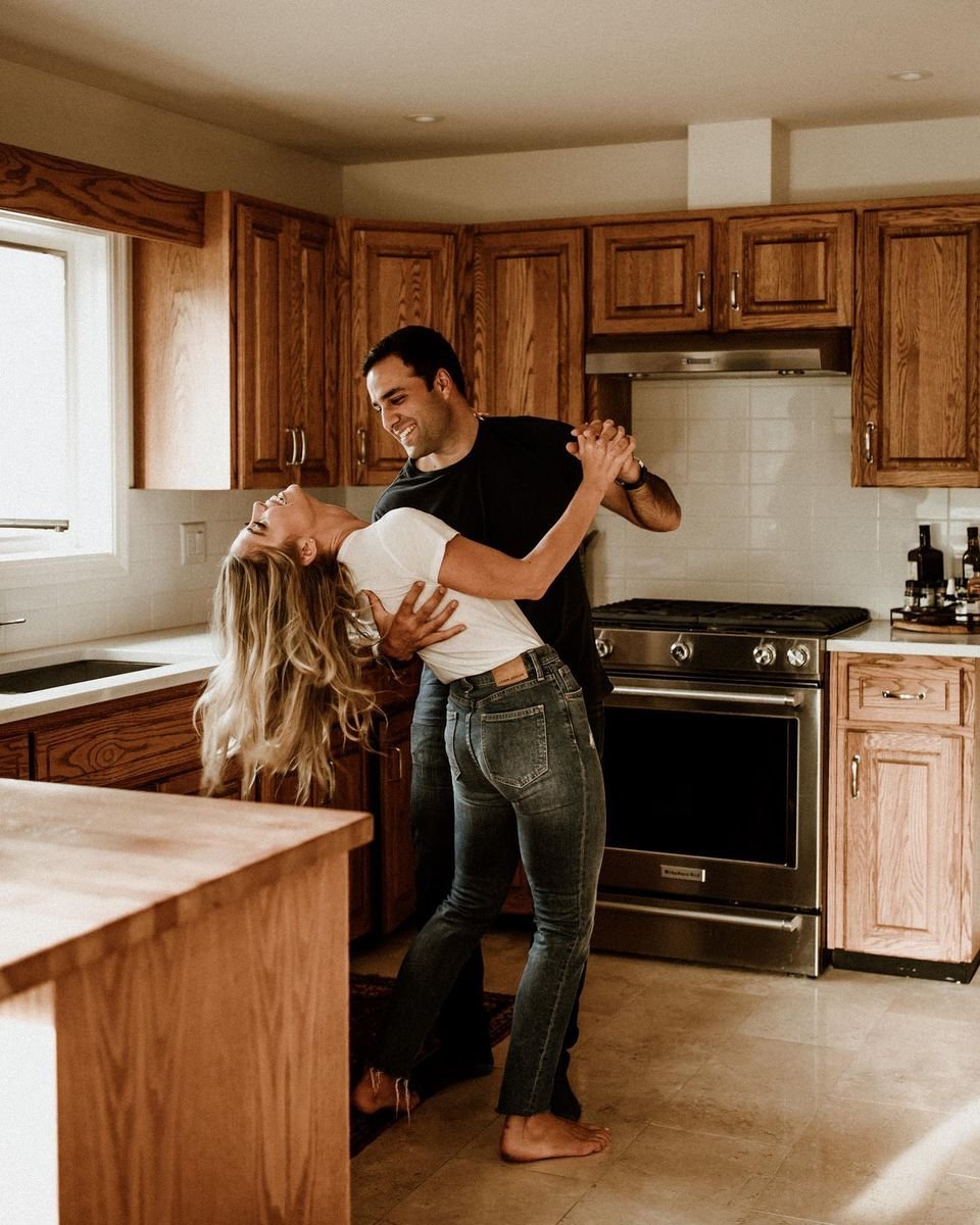 Laughing couple dancing together in a cozy kitchen