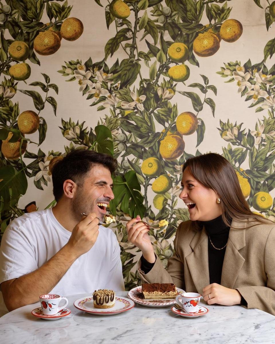 Couple sharing dessert at a cafe table