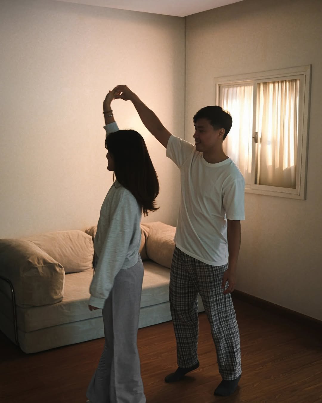 Man twirling a woman as they dance in a living room