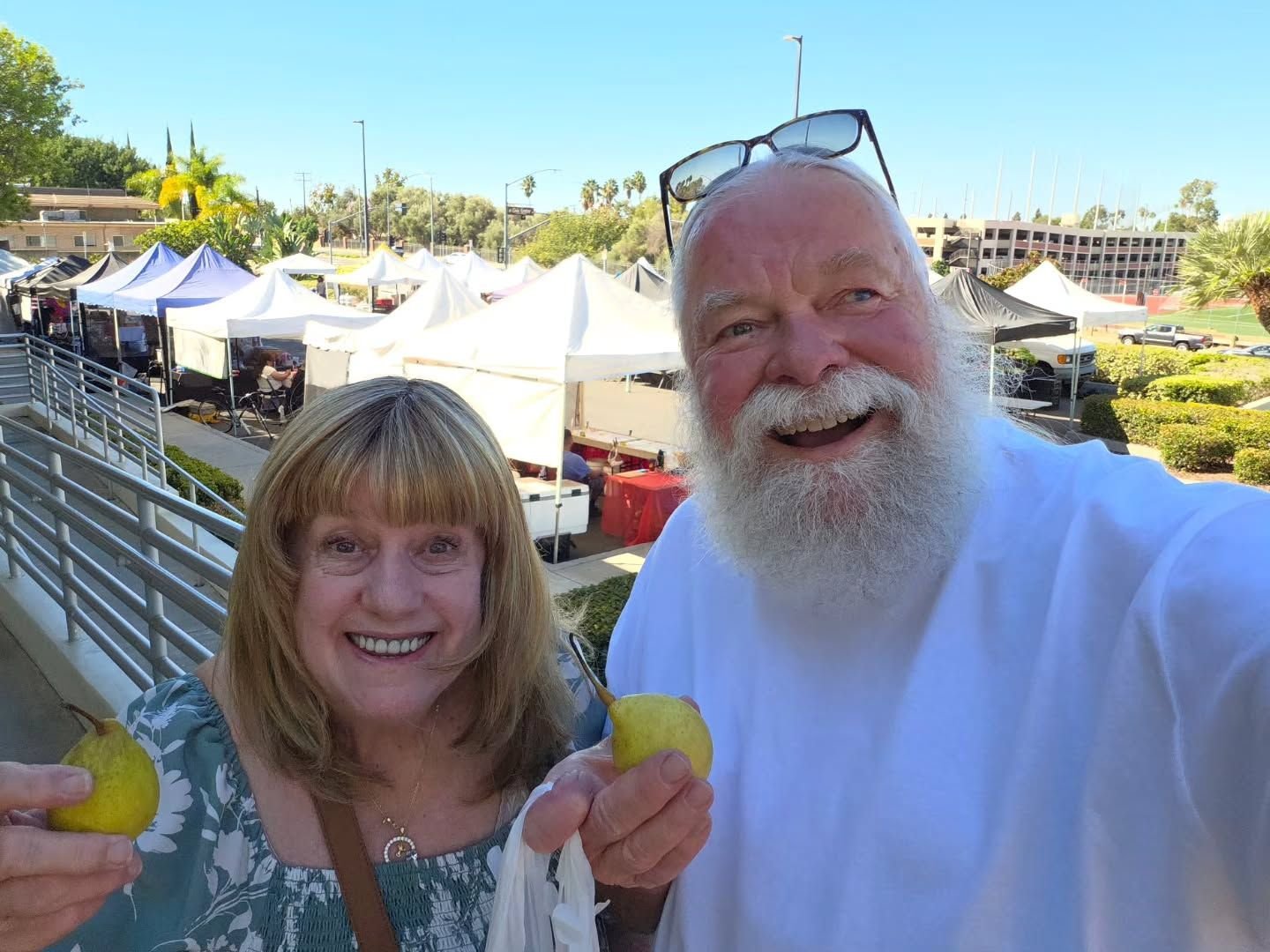 Older couple holding pears at a farmers market