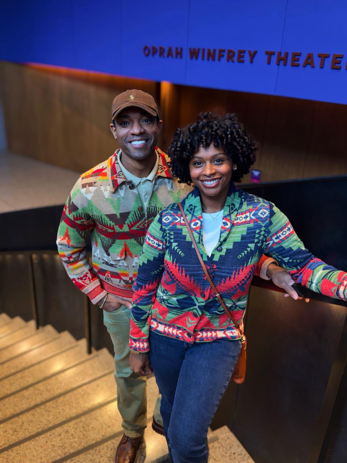 Couple in matching cardigans at a museum theater entrance