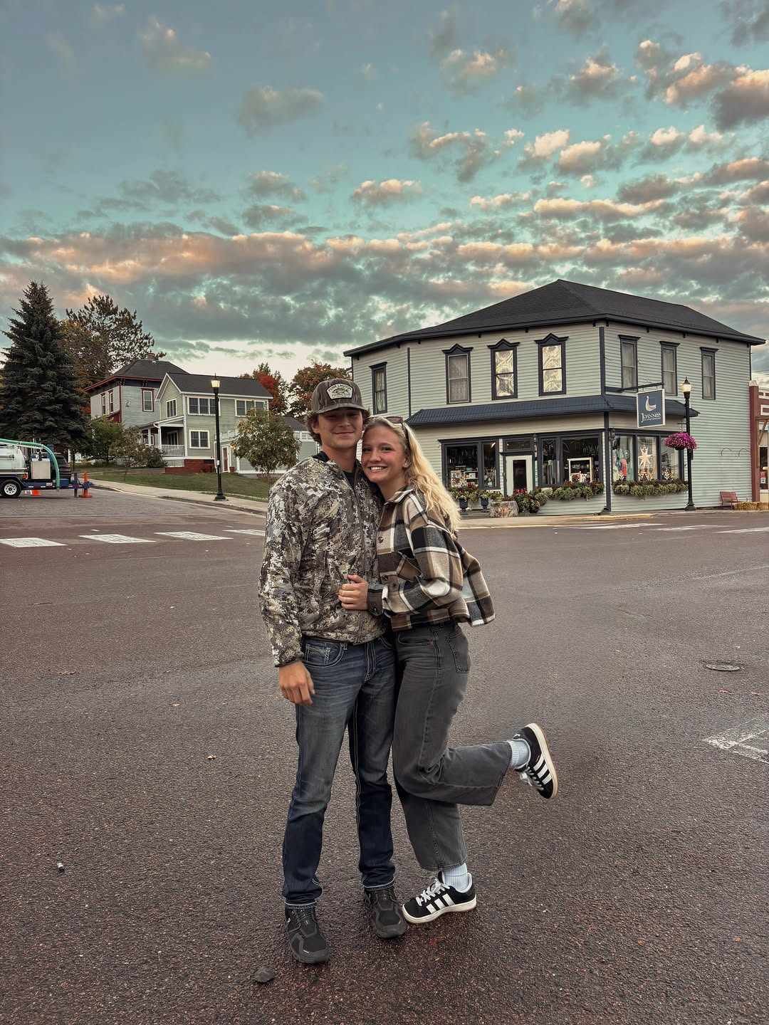 Young couple on a small-town street at sunset by a brick building