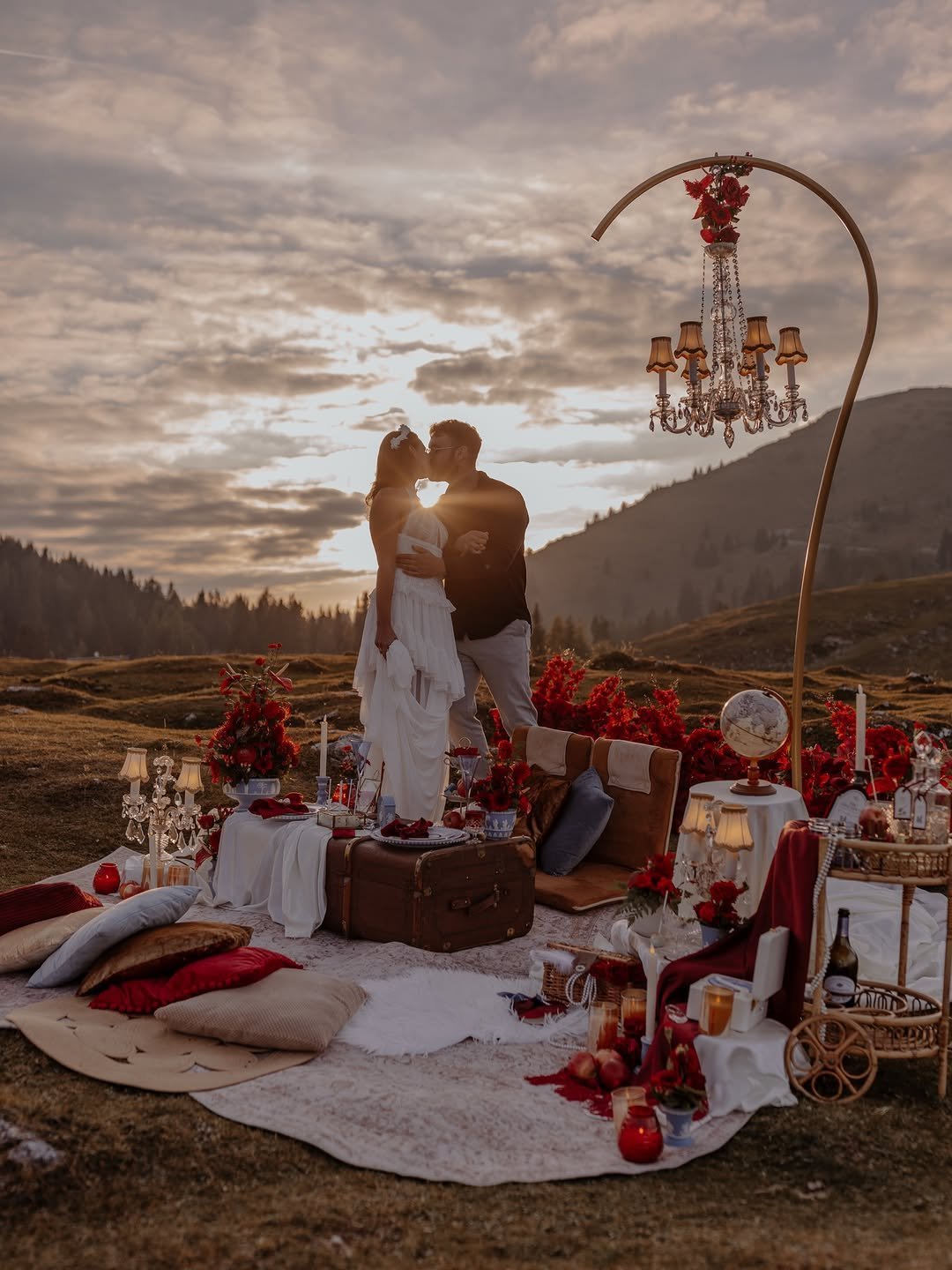 Couple embracing at a sunset picnic in the mountains