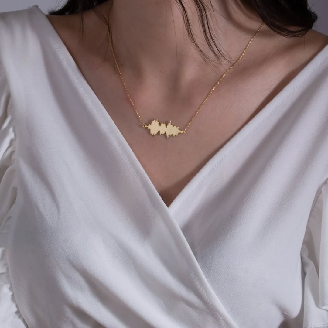 Gold soundwave pendant necklace worn