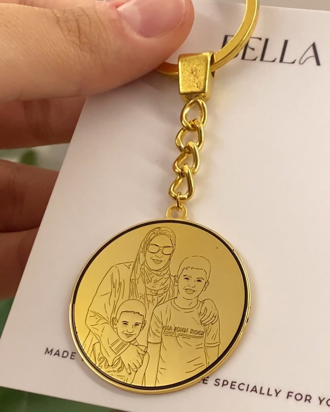 Hand holding engraved photo keychain