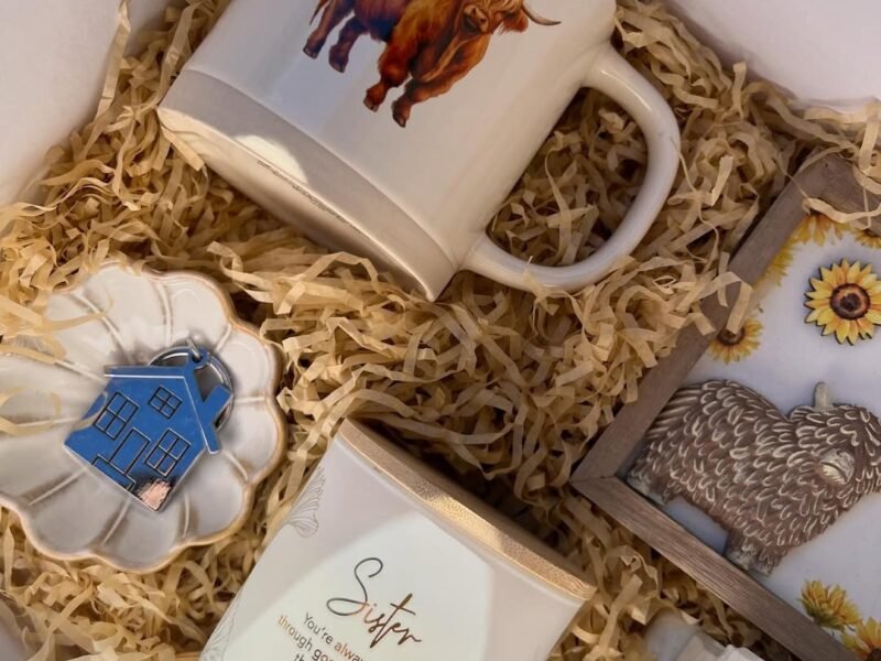 Gift box flat lay with mug, candle and trinket dish