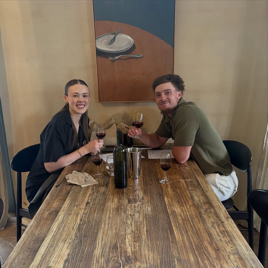 Couple with red wine glasses at winery tasting table