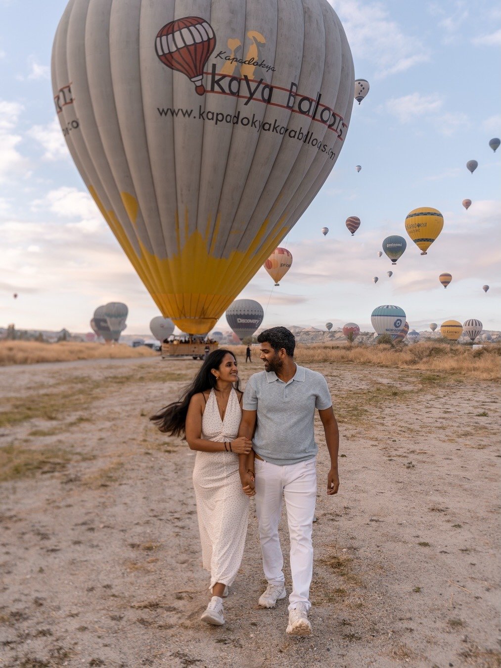 Couple in front of hot air balloon at sunrise Cappadocia