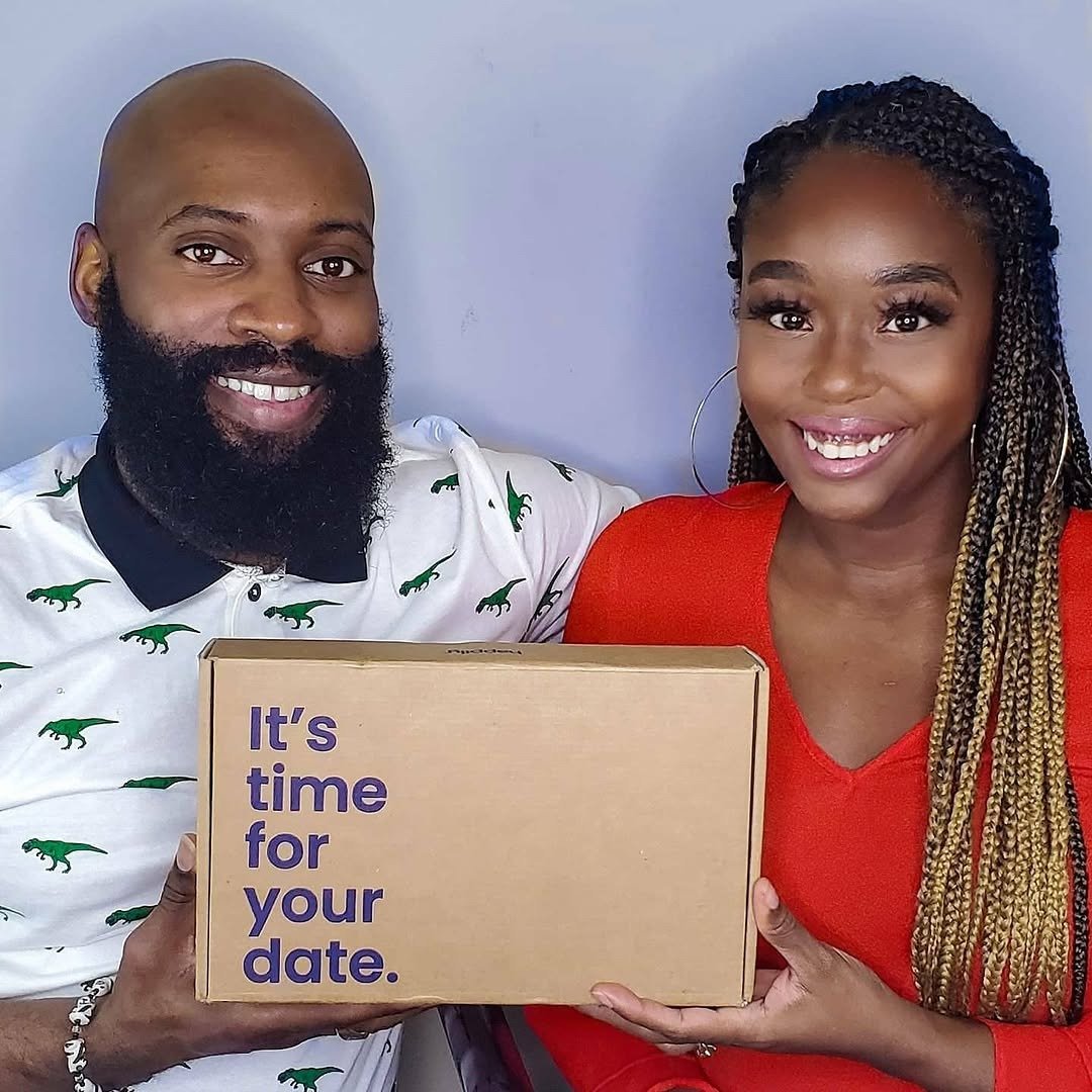 Couple at home holding date night subscription box