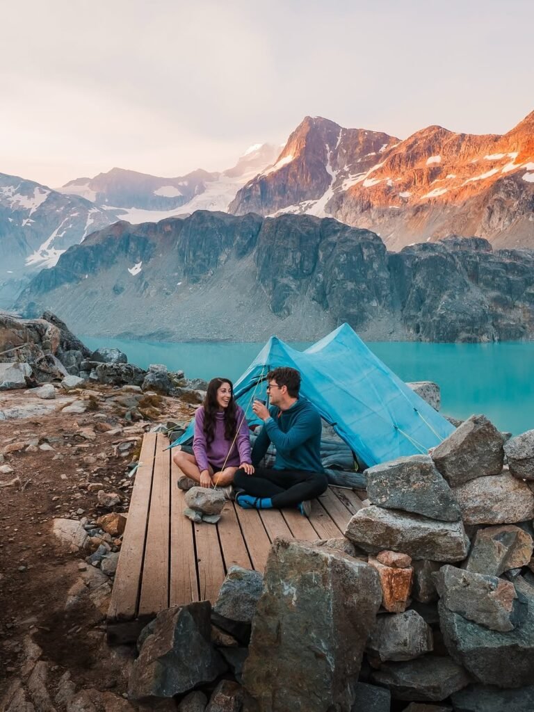 Couple laughing at alpine campsite by mountain lake