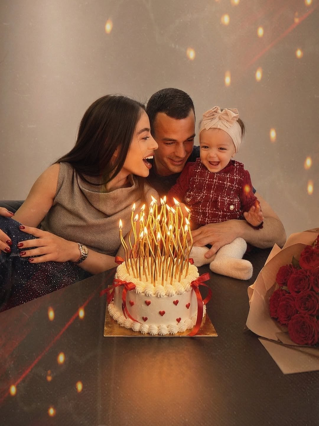 Couple laughing behind a birthday cake full of lit candles, from our first birthday together guide