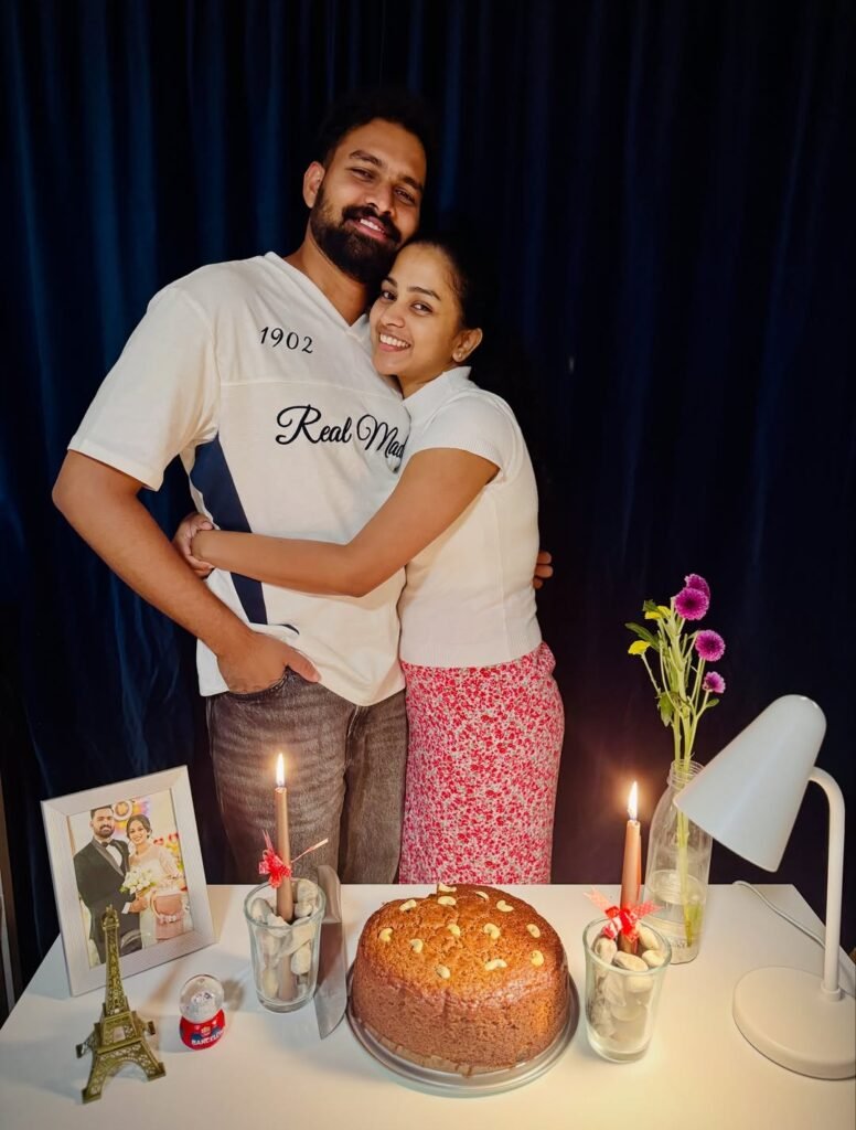 Happy couple hugging behind a birthday cake with candles
