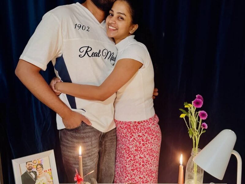 Happy couple hugging behind a birthday cake with candles