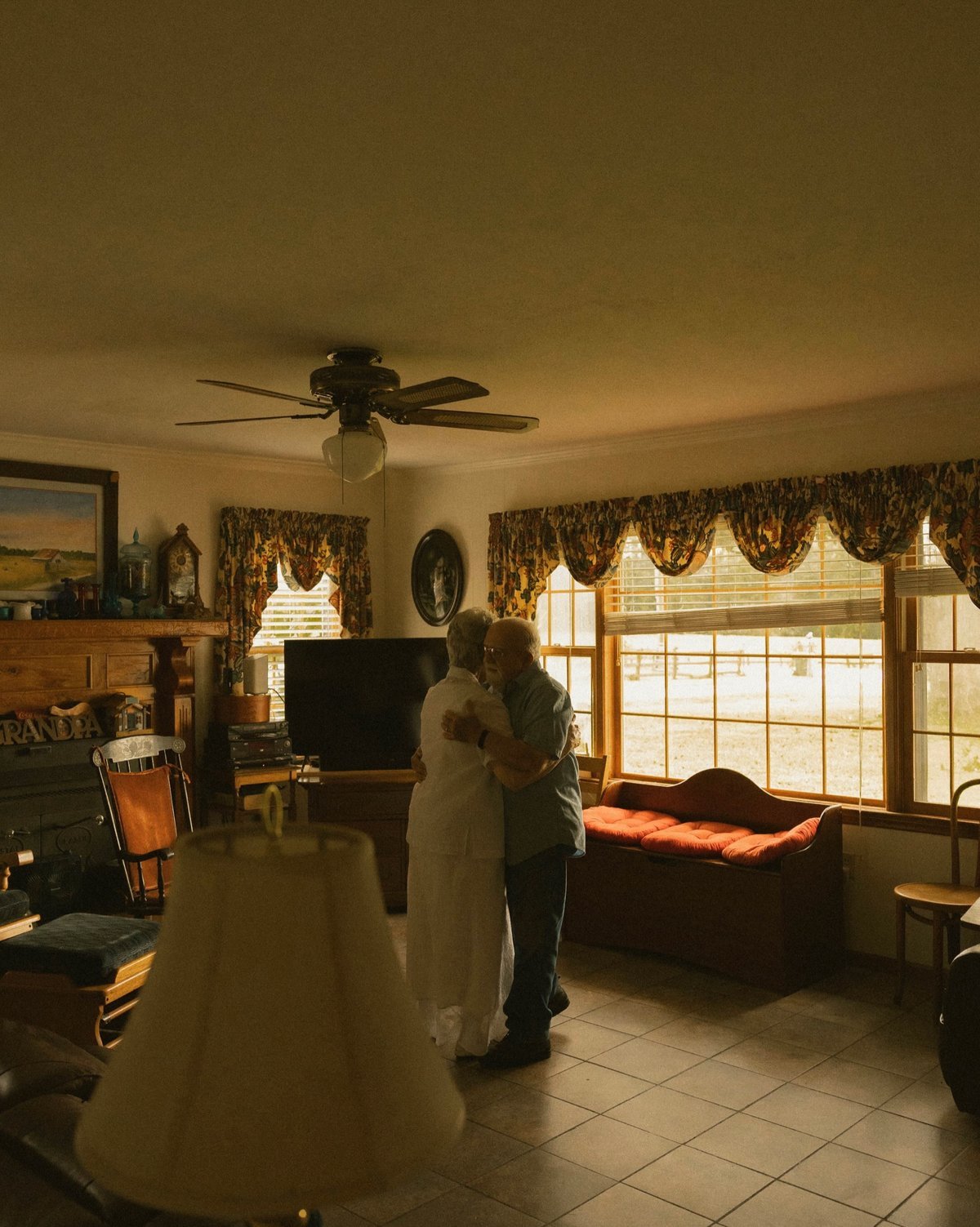 Older couple slow dancing together in their living room