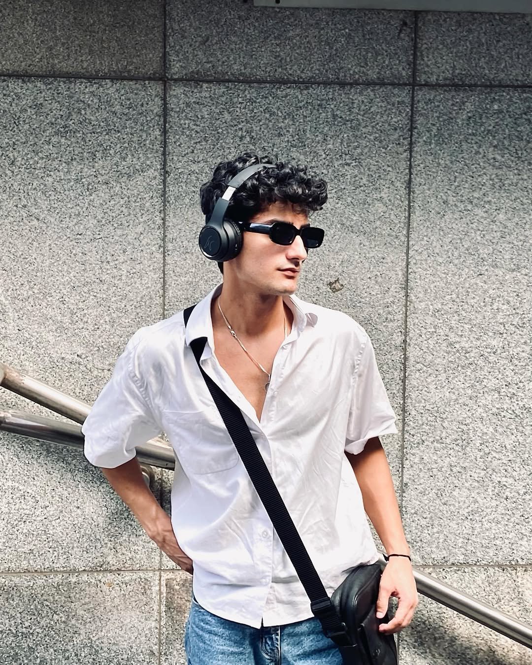 Young man in sunglasses wearing black over-ear headphones, from our gift ideas guide