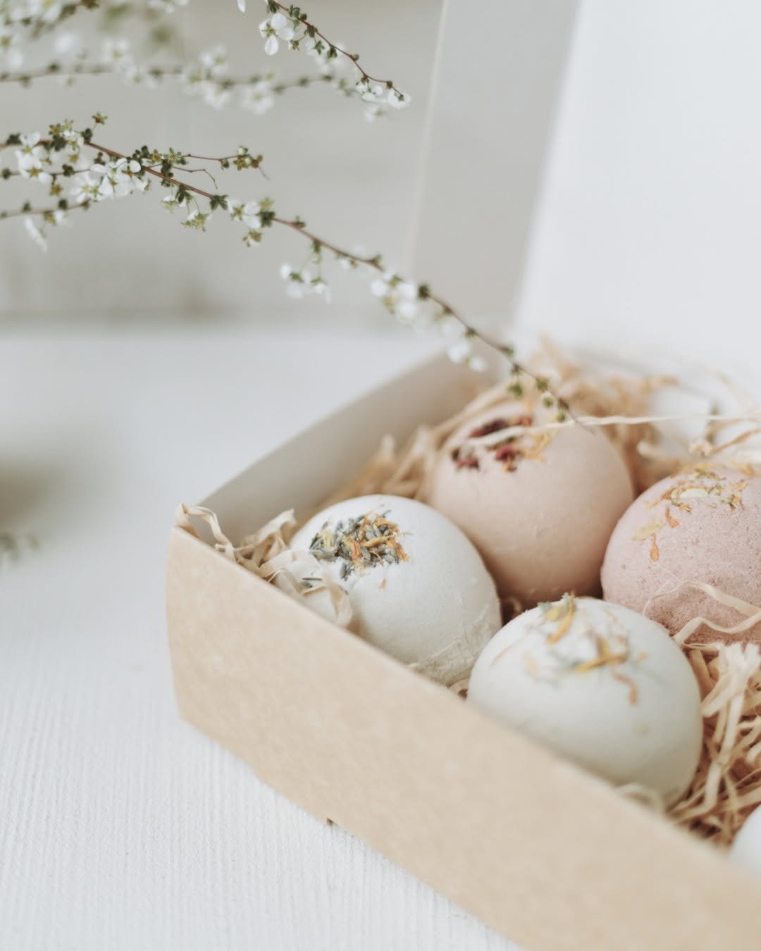 Bath bombs in an open gift box with dried flowers