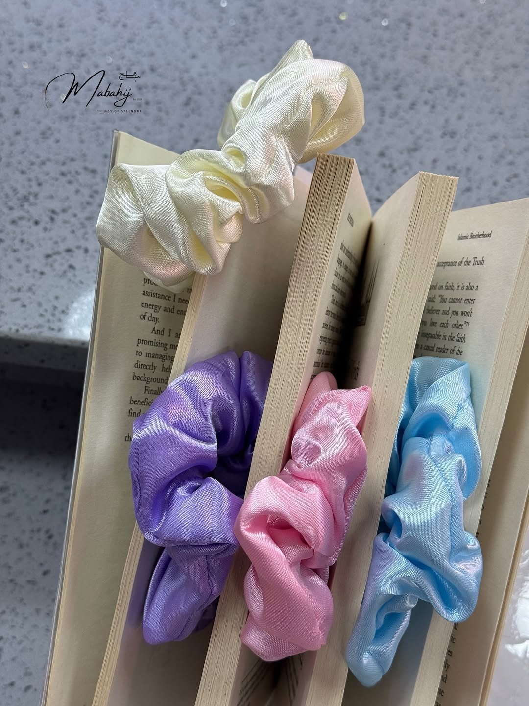 Satin scrunchies in soft colours over open books