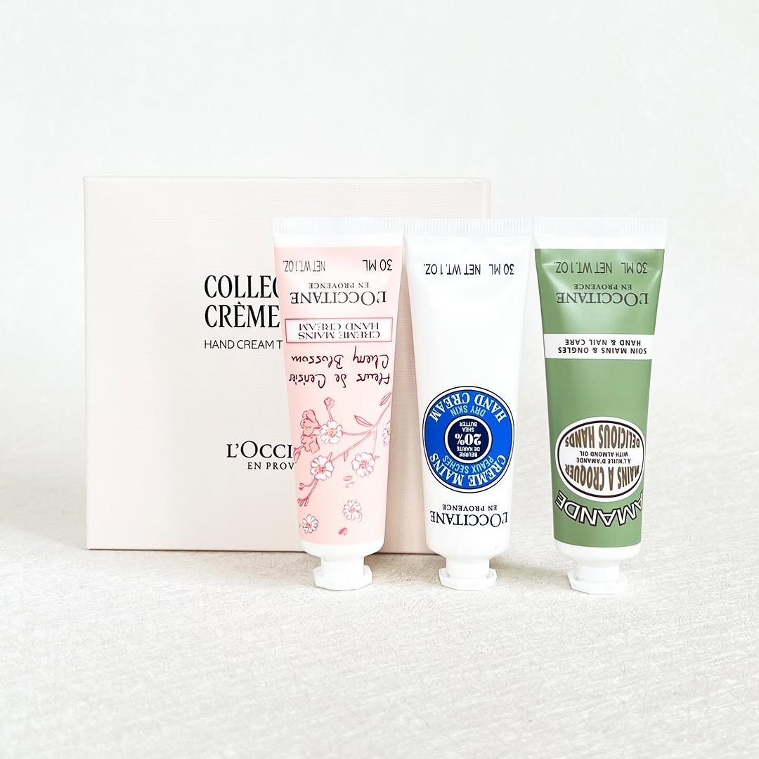 Three hand cream tubes in front of a gift box