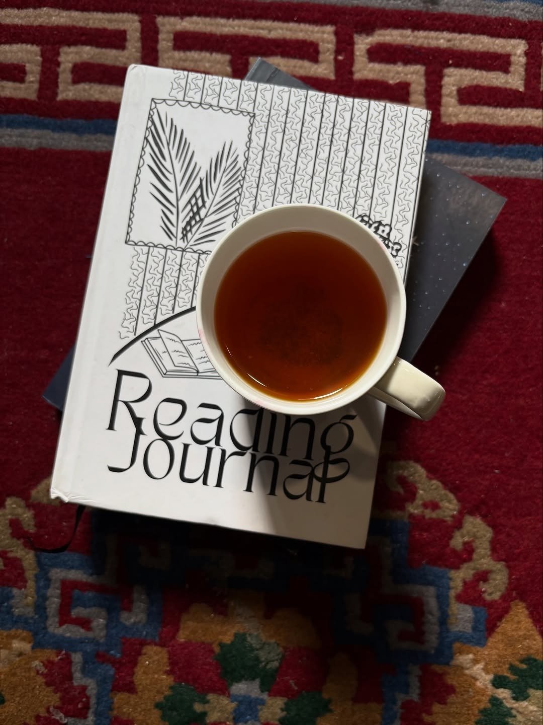 Reading journal on a book with a cup of tea