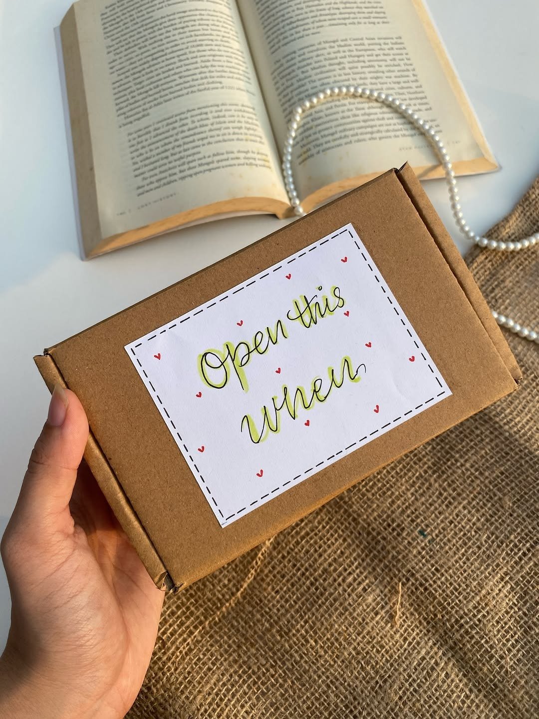 Hand holding open when letters gift box