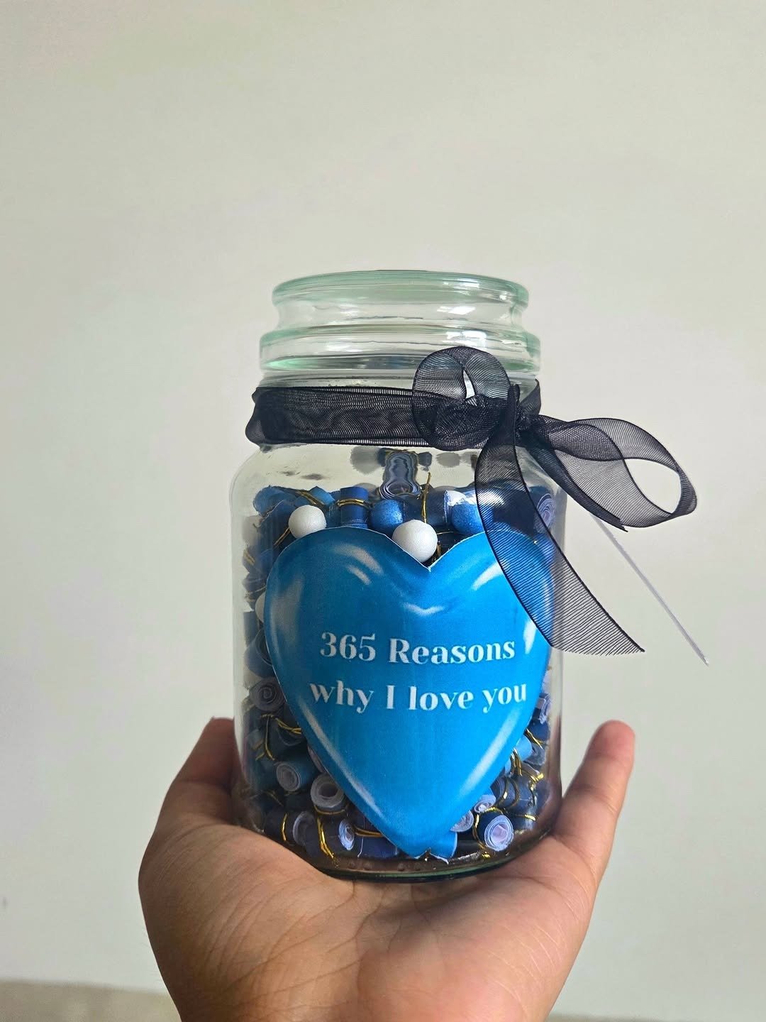 Glass jar filled with rolled love notes and ribbon