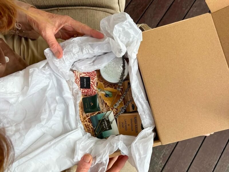 Woman opening a gift box with pamper treats at home