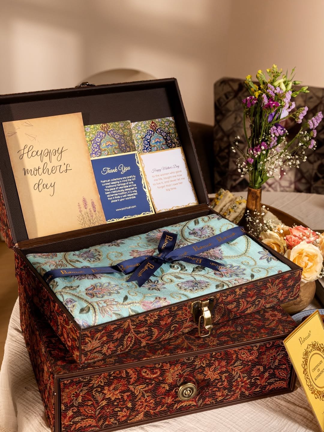 Gift box with handwritten card and wrapped gift with flowers