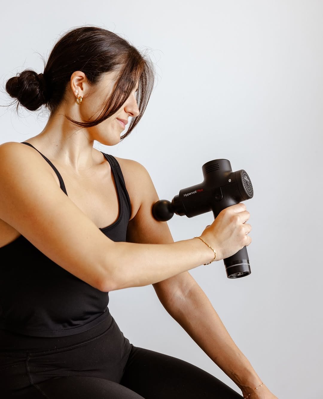Massage gun used on upper arm
