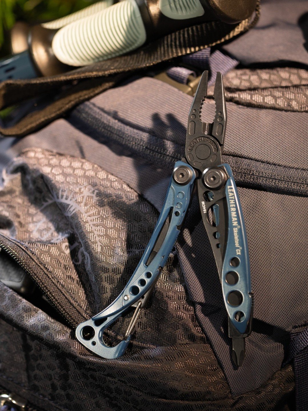 Blue Leatherman multi-tool on backpack outdoors