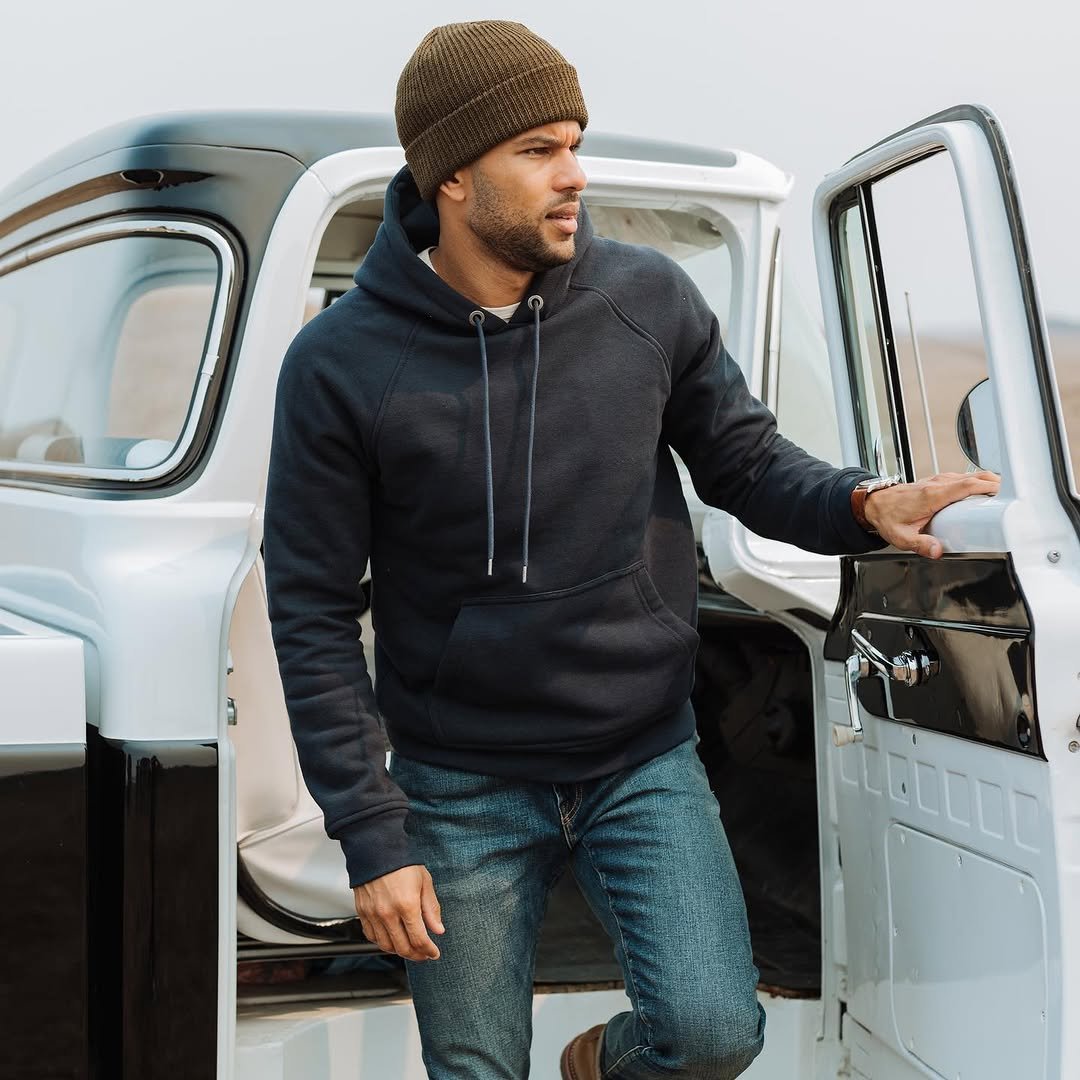 Man in dark heavyweight hoodie by vintage truck