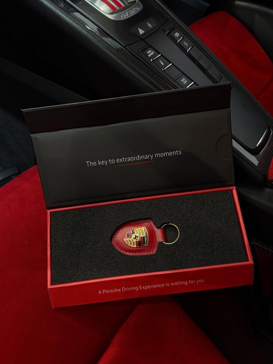 Opened driving experience gift box on red car seat