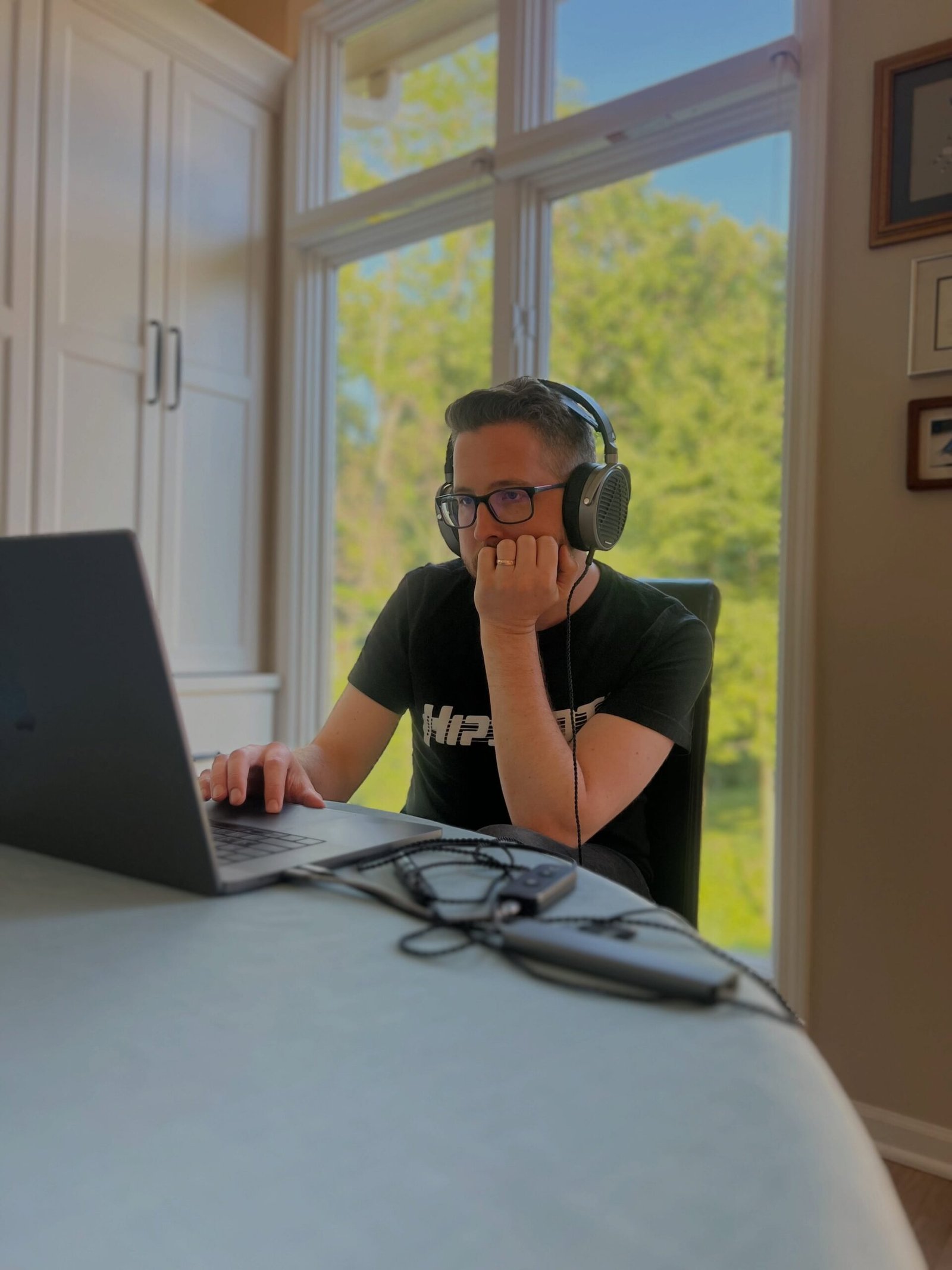 Man with headphones working on laptop at desk, from our gifts for husband guide