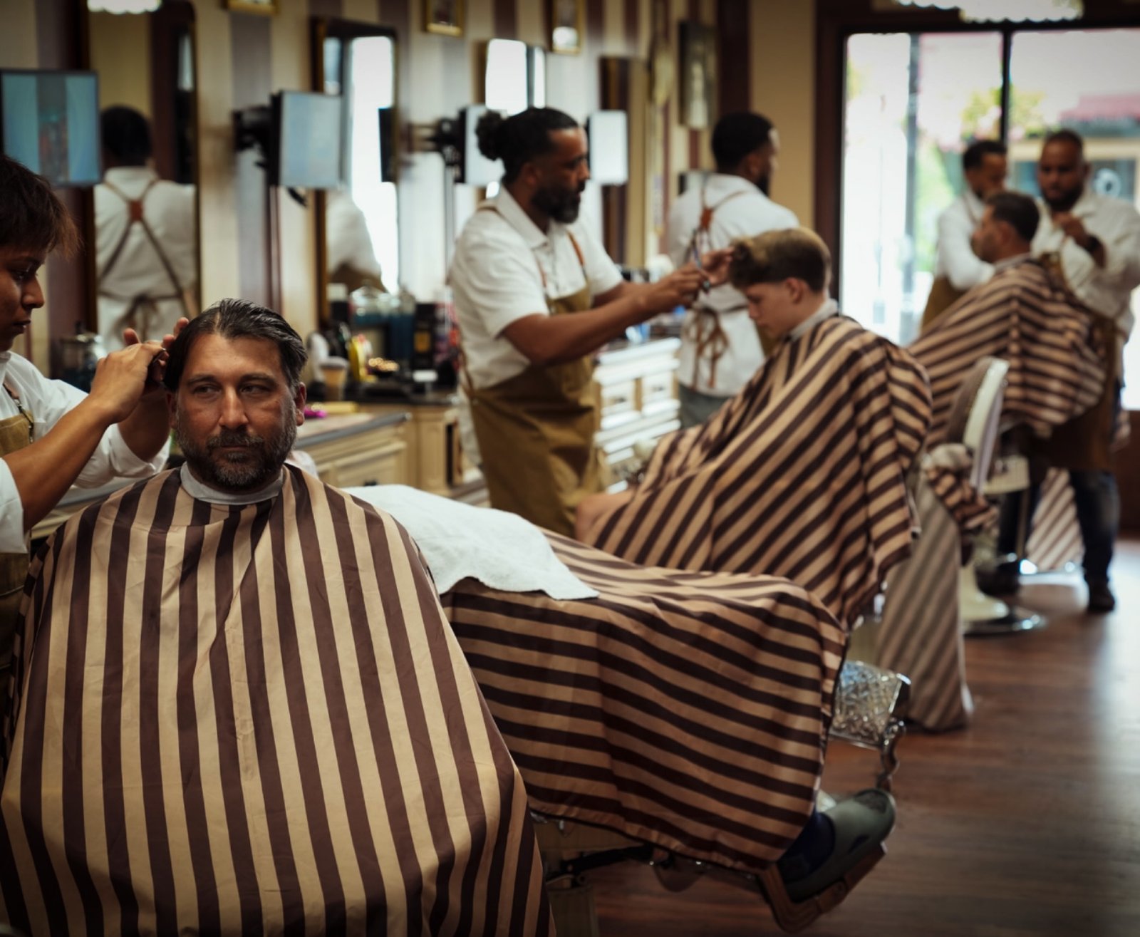 Barbers cutting hair in traditional barbershop