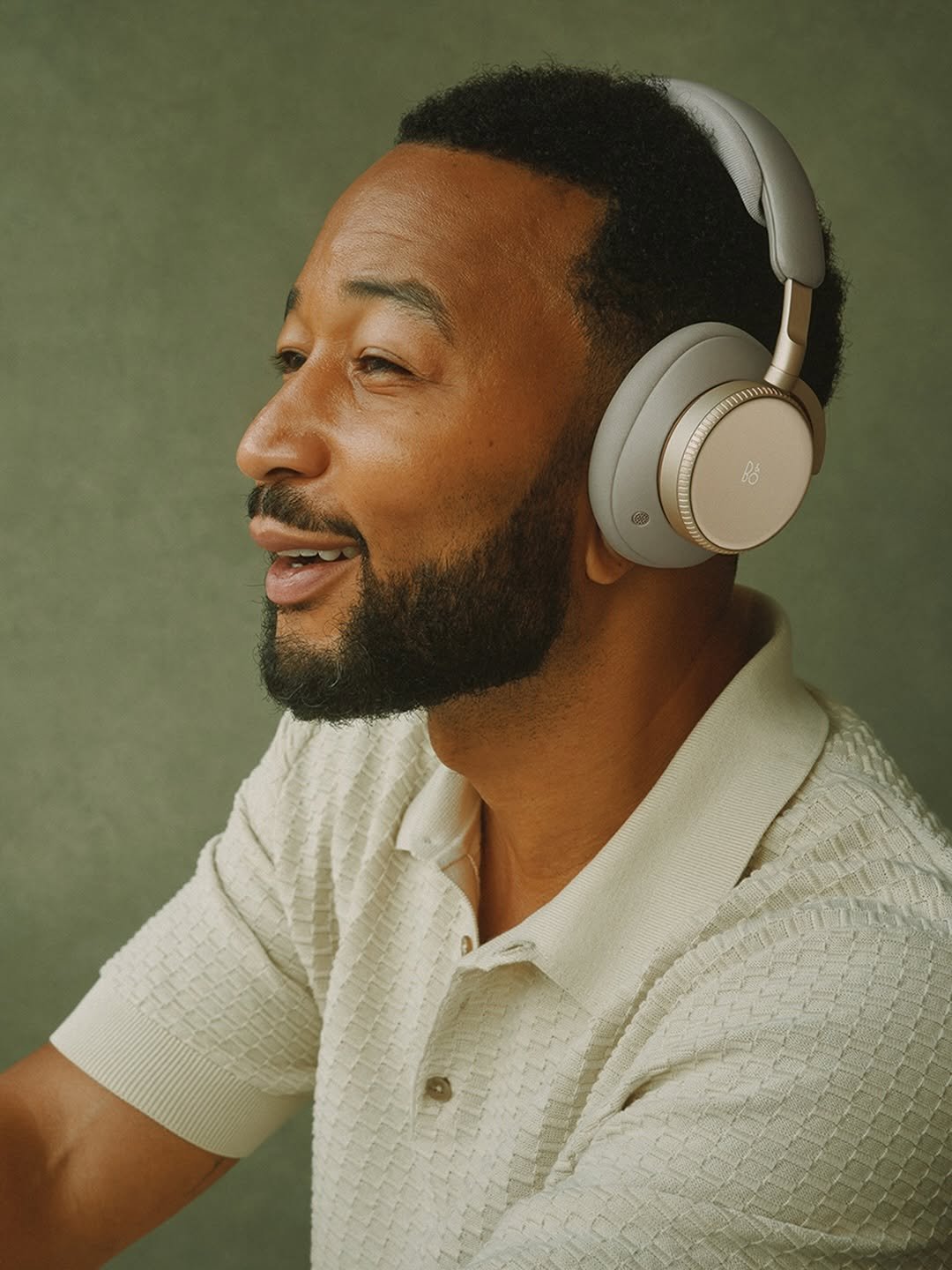 Man wearing Bang and Olufsen over-ear headphones, lifestyle portrait