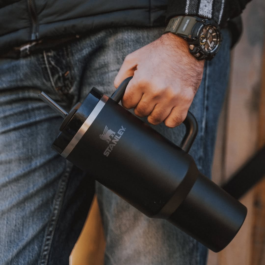 Hand holding black Stanley Quencher tumbler lifestyle shot