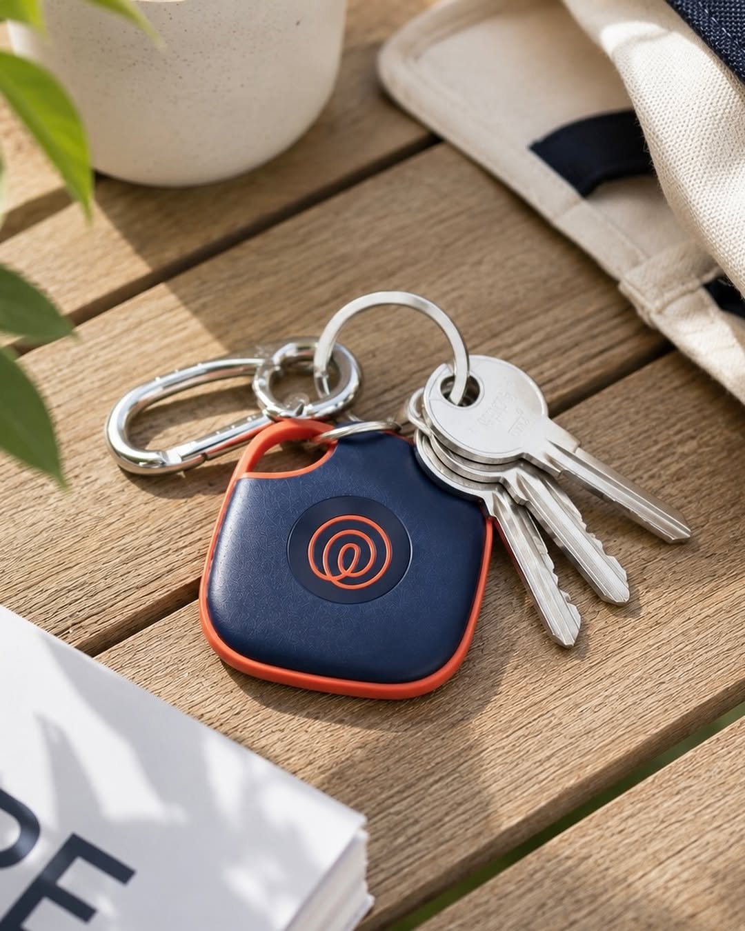 Tile Bluetooth tracker attached to keys on wooden table